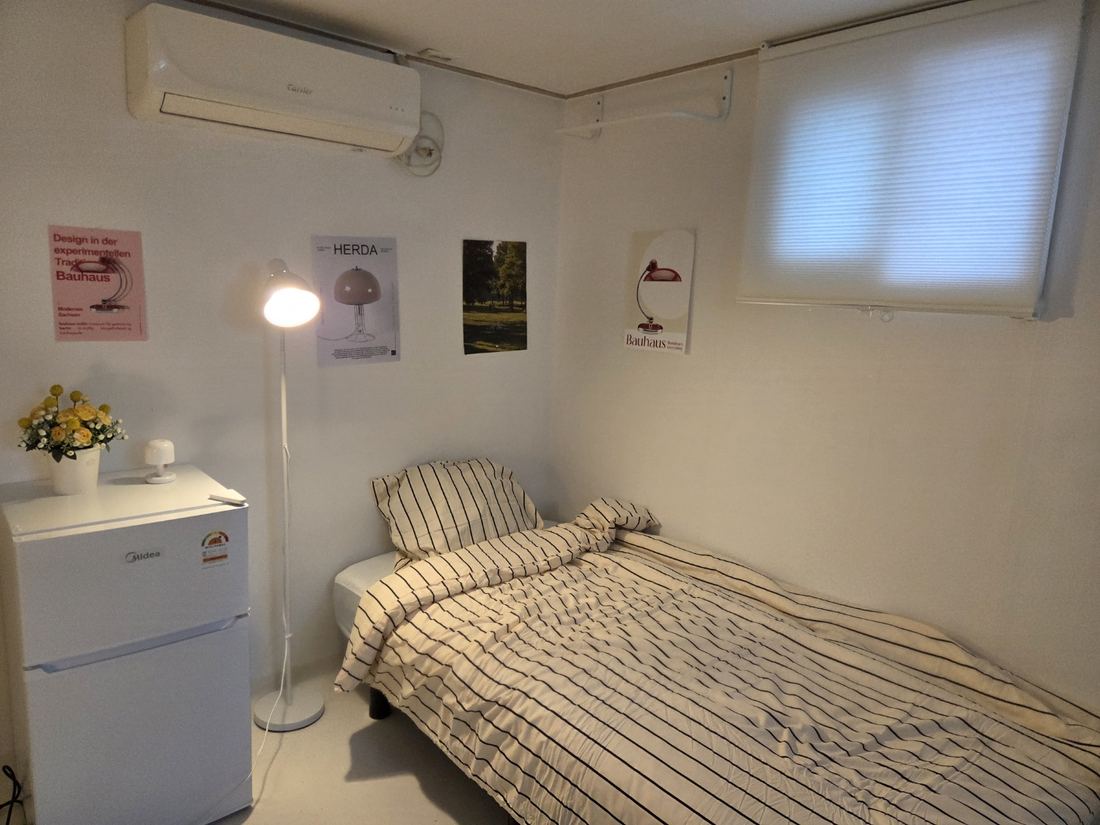 가산동 고시원 끄라샤하우스 가산점 스탠드 조명이 켜진 객실