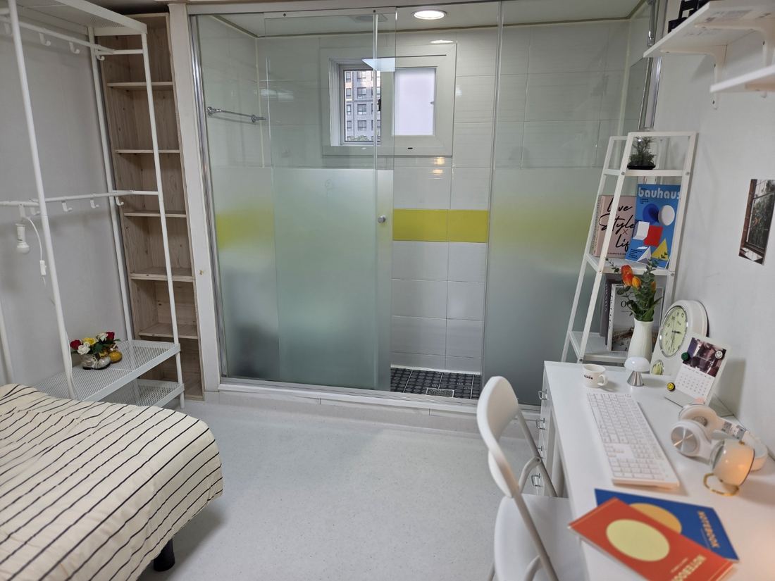가산동 고시원 끄라샤하우스 가산점 침대와 책상이 마주 놓인 객실